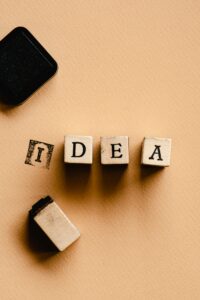 Top view of letter stamp tiles forming the word 'IDEA' on textured surface, symbolizing creativity.